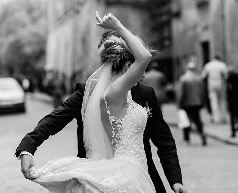 Tanzendes Brautpaar auf der Straße, schwarz-weiß Bild